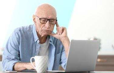 Man sitting at a table with the laptop open